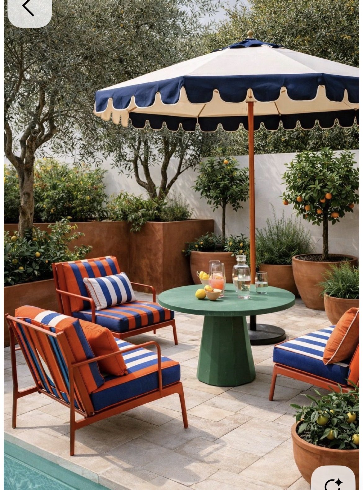 Outdoor scene: orange and navy striped garden chairs with a green table and umbrella — Furnea lifestyle output
